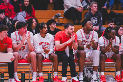 members of the varsity basketball team watching a game from their bench