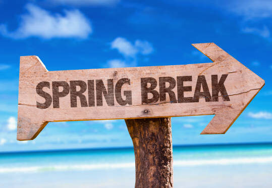 Arrow sign with "Spring Break" on it in front of beach