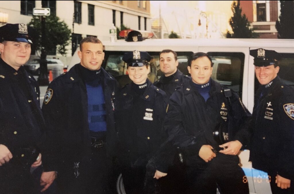Photo of six NYPD uniformed officers posing on a street.