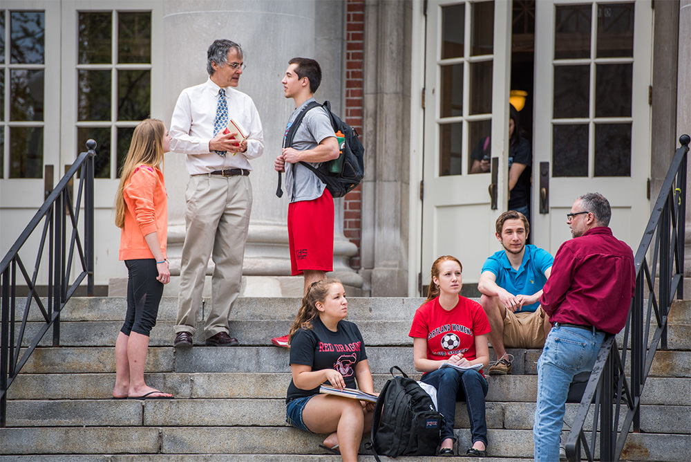 Honors Program faculty and students chat on the steps of Old Main