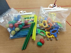 Three musical kits from the TMC collection containing egg shakers, rhythm sticks, and easy grip jingle bells